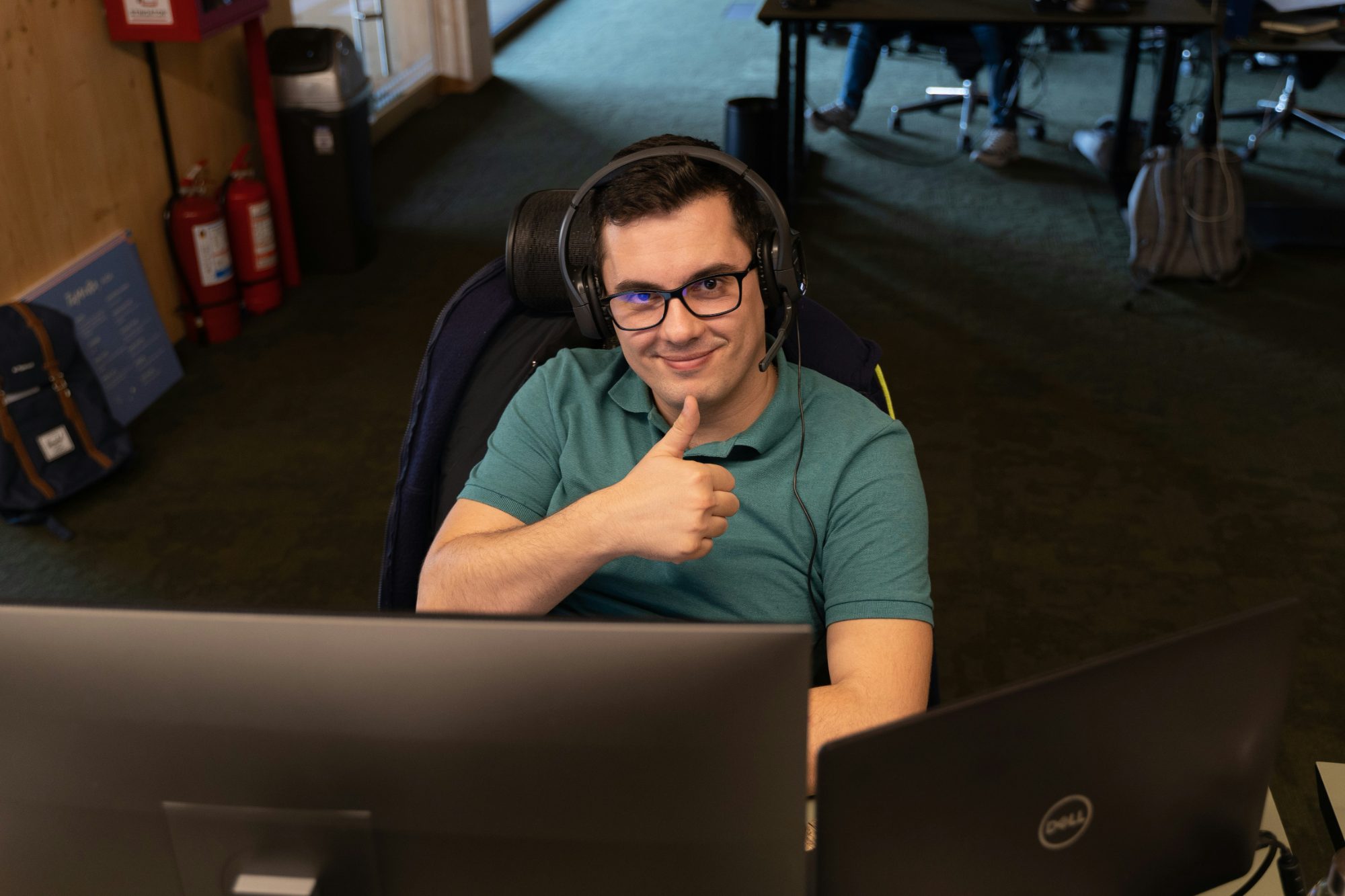 Développeur souriant avec casque, pouce levé